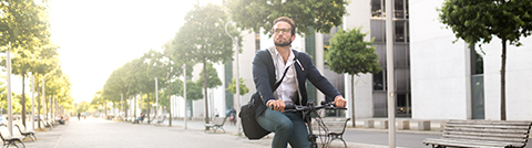 ESG: Homem andando de bicicleta na rua de uma cidade.