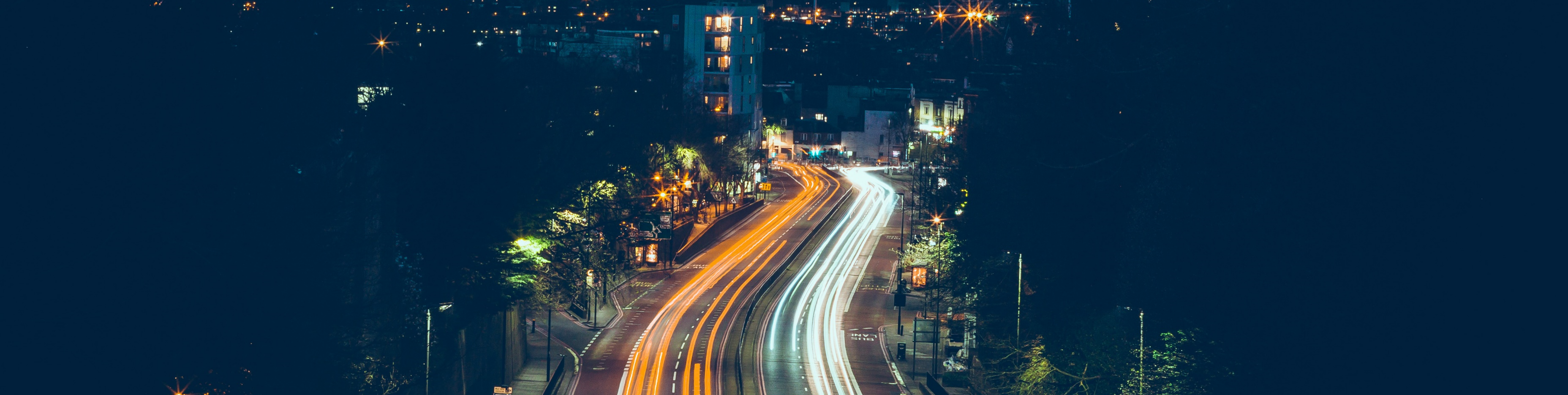 Avenida com luzes de farol de noite